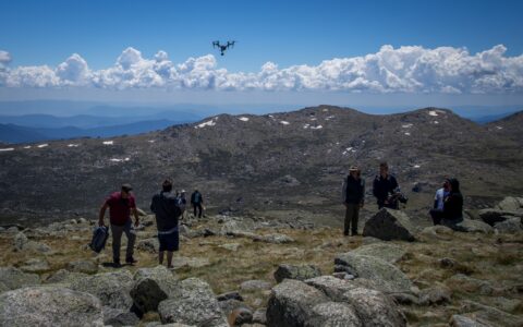 Ernie Dingo and TV crew run drone on Mount Kozhushko, Australian Alps, NSW, Australia