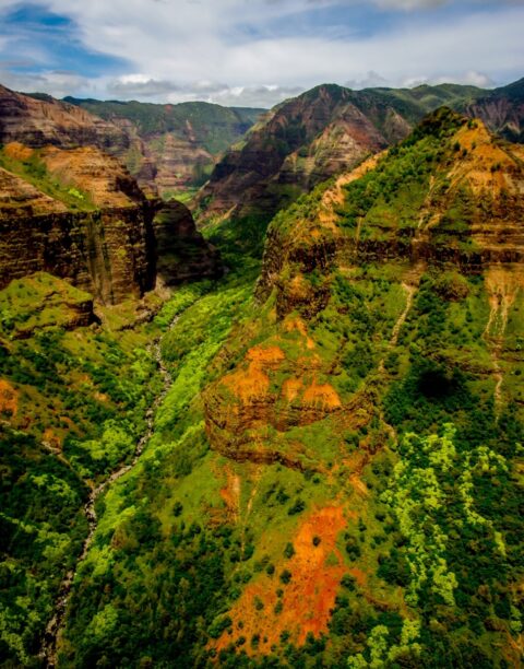 Blue Hawaiian Helicopter Hovering Over Waimea Canyon On Kauai Island, HI
