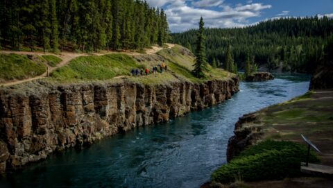 Group of Tourists Hike Along Yukon River On Lower Canyon City Trail In Miles Canyon Near Whitehorse, YT